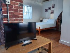sala de estar con TV de pantalla plana y cama en Number Three en Brighton & Hove