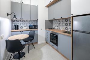 a kitchen with white cabinets and a table and chairs at Apartments on Krakowska street in Lviv