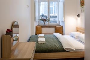 a bedroom with a bed with a table and a window at Apartments on Krakowska street in Lviv