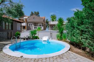 a swimming pool in a yard with a house at Ktima Papaoikonomou in Potos