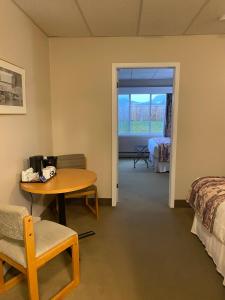 Cette chambre dispose d'une table, d'un lit et d'une table. dans l'établissement Ocean View Hotel, à Rocky Harbour