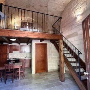 a staircase in a kitchen with a table and a dining room at la casetta nel borgo wood in Borgagne