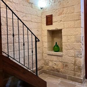 a staircase with a green vase sitting on a shelf at la casetta nel borgo wood in Borgagne