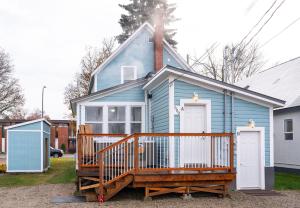a blue house with a large deck and a porch at Downtown Heritage Home W/ Hot Tub 509 Mackenzie in Revelstoke