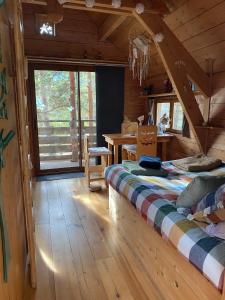 1 dormitorio con 1 cama en una cabaña de madera en Les Cabanes de Maya, en Caille
