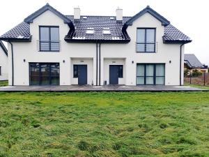 a white house with a black roof at AJP Prestige House Szczecin Załom in Szczecin