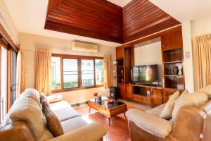 een woonkamer met 2 banken en een tv bij Bali Haven 3BR PrivatePool Villa in Pattaya South