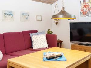 a living room with a purple couch and a table at 8 person holiday home in Grenaa in Grenå