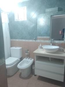 La salle de bains est pourvue de toilettes blanches et d'un lavabo. dans l'établissement Casa amplia con pileta 9 personas, à Luján de Cuyo