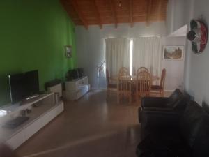 - un salon avec un canapé et une télévision dans l'établissement Casa amplia con pileta 9 personas, à Luján de Cuyo