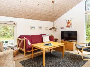 a living room with a couch and a table at 8 person holiday home in Grenaa in Grenå