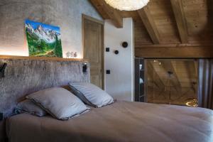 ein Schlafzimmer mit einem großen Bett in einem Zimmer in der Unterkunft Les Chalets PVG in La Clusaz