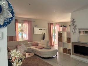 a living room with a couch and a tv at VILLA AVEC PISCINE in Néoules