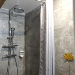 a shower with a glass door in a bathroom at La Tour de Coron in Belley