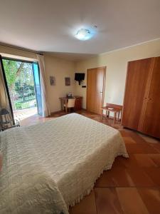 1 dormitorio con 1 cama grande y puerta corredera de cristal en Casale Delle Arti, en Mosciano SantʼAngelo