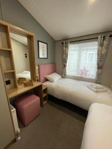1 dormitorio con 2 camas y ventana en Rye Harbour Holiday Park en Rye Harbour
