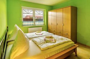 a bedroom with green walls and a bed and a cabinet at Mediterranes Flair mit Seeblick in Nenndorf