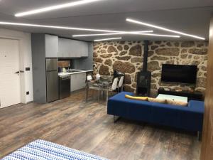 a living room with a blue couch and a stone wall at Casa Velha Azeitona in Tábua