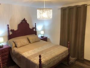 um quarto com uma cama e um lustre em Casa Velha Azeitona em Tábua