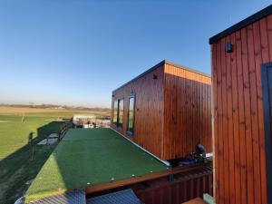a house with a green lawn on the roof at Tiny House Betuwe in Tricht