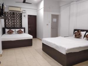 a bedroom with two beds in a room at Adarsh Hotel in Port Blair +5 photos