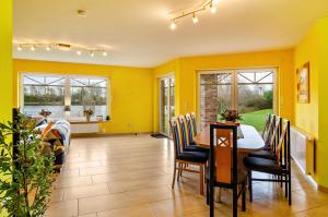 a dining room with yellow walls and a table and chairs at Mediterranes Flair mit Seeblick in Nenndorf
