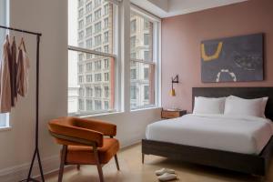 sypialnia z łóżkiem, krzesłem i oknami w obiekcie Sonder Flatiron w Nowym Jorku