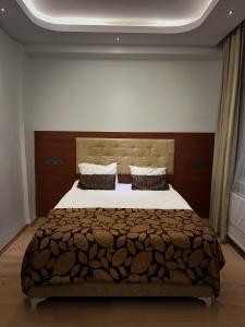 a bedroom with a large bed with a wooden headboard at Ankara Santral Otel in Altındağ