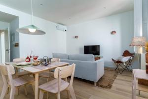 een woonkamer met een tafel en een bank bij Modern & Cozy Faro Mercado Apt 21 in Faro