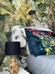 a bedroom with a bed with an elephant and a lamp at Studio tropical , vierzon , proche gare , tout confort in Vierzon