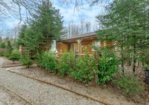 a log cabin with a garden in front of it at Squirrel in Postling