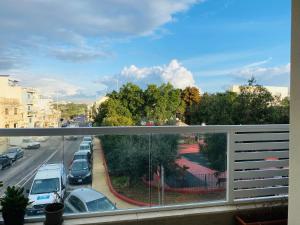 Elle comprend un balcon offrant une vue sur une rue de la ville. dans l'établissement Soleil, à Gudja