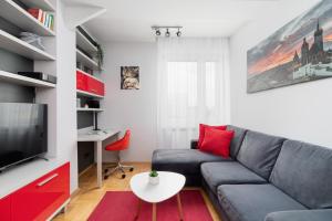 sala de estar con sofá gris y almohadas rojas en Łagiewniki Sanctuary One Bedroom Apartment by Renters en Cracovia