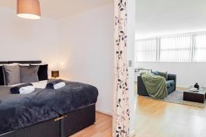 a bedroom with a bed and a living room at Cosy Apartment near Nottingham City Centre in Nottingham