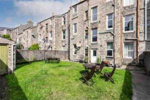 a yard with a table and chairs in front of a building at Stunning 1-Bed Apartment in Aberdeen city centre in Aberdeen