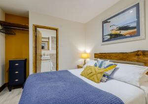 a bedroom with a blue and white bed and a mirror at Badger in Postling