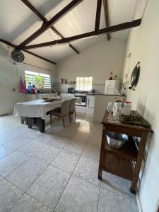 a large room with a table and a kitchen at Sítio Gran Royalle in Sete Lagoas