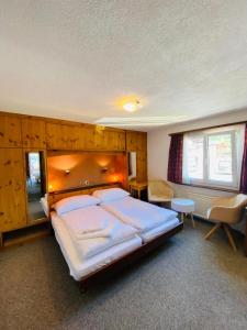 een slaapkamer met een groot bed met een houten hoofdeinde bij Hotel Old JNN in Klosters Serneus