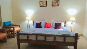 - une chambre avec un lit et des oreillers rouges dans l'établissement Jungle Heritage, à Paliā Kalān