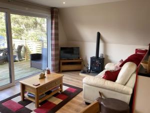 a living room with a couch and a television at Lodge 24 in Spean Bridge