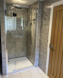 a shower with a glass door in a bathroom at Lodge 24 in Spean Bridge