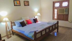 Paliā KalānにあるJungle Heritageのベッドルーム1室(大型ベッド1台、カラフルな枕付)