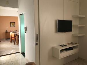 sala de estar con TV de pantalla plana en la pared en Casa no Centro de Piumhi en Piumhi