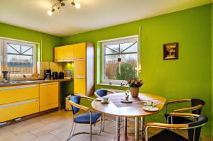 eine Küche mit einem Tisch und Stühlen im Zimmer in der Unterkunft Haus mit Seeblick in Nenndorf