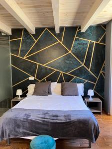 1 dormitorio con 1 cama grande y una pared grande en Hospederia El Batan, en Tramacastilla