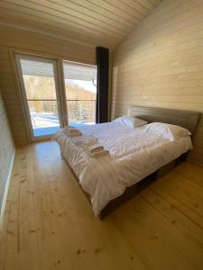 uma cama grande num quarto com duas janelas em Soul House em Bagna
