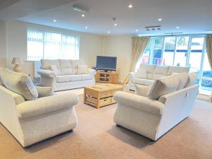 a living room with three chairs and a television at Whittonlodge sleeps26 in Hardstoft