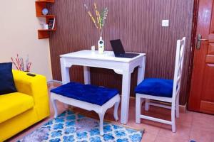 Habitación con mesa, ordenador portátil y 2 sillas en Naivasha 2 Bedroom Rated Best, en Naivasha