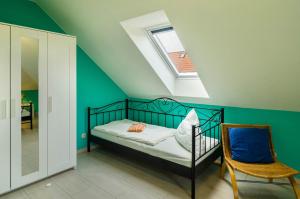 ein kleines Schlafzimmer mit einem Bett und einem Stuhl in der Unterkunft Haus mit Seeblick in Nenndorf