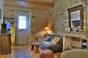 - un salon avec un canapé et un mur en pierre dans l'établissement La maison du facteur, à Saint-Denis-dʼOléron